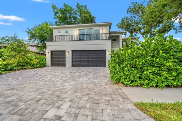 view of front of property featuring a balcony and a garage