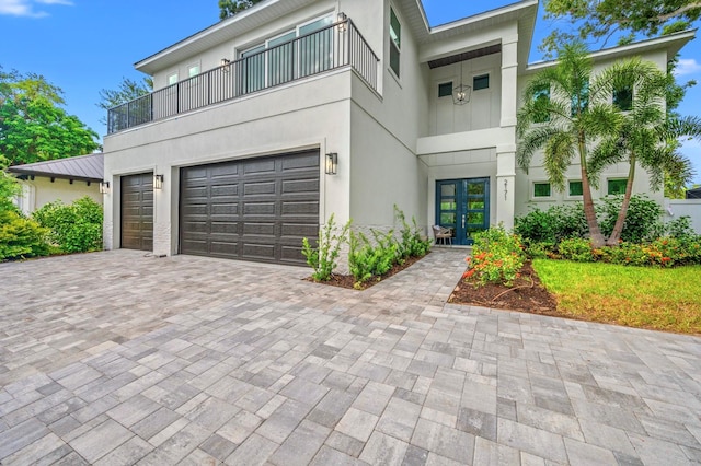 contemporary house featuring french doors, a balcony, and a garage