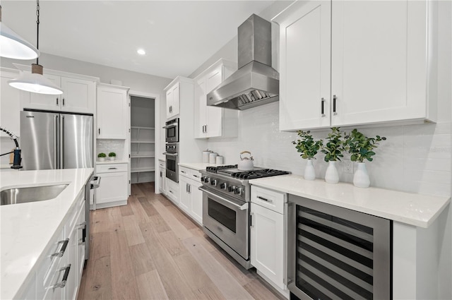 kitchen featuring white cabinets, high end appliances, exhaust hood, and wine cooler