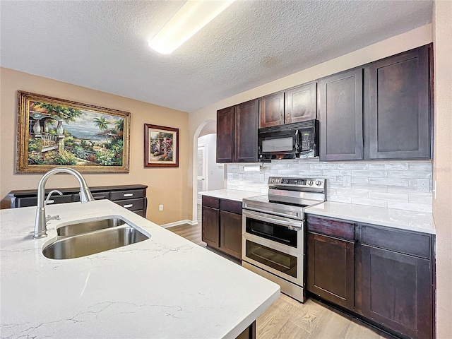 kitchen with double oven range, backsplash, sink, a textured ceiling, and light hardwood / wood-style floors