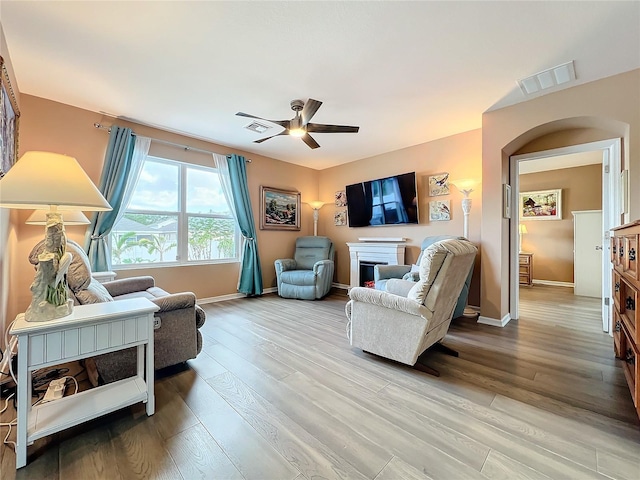 living room featuring ceiling fan and light hardwood / wood-style floors