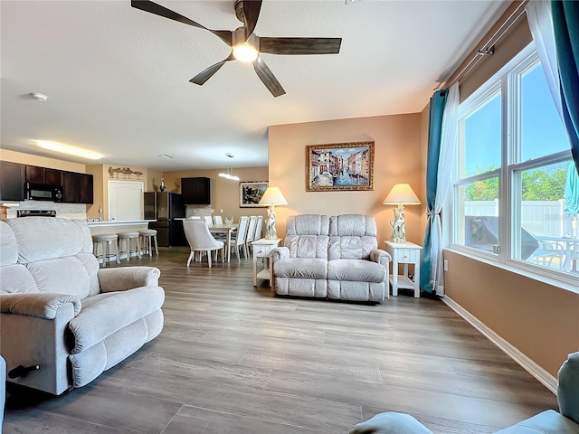 living room with ceiling fan, light hardwood / wood-style flooring, and sink