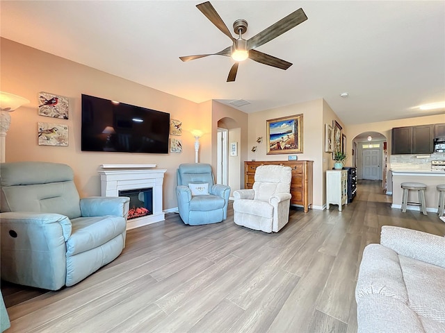 living room featuring light hardwood / wood-style floors and ceiling fan