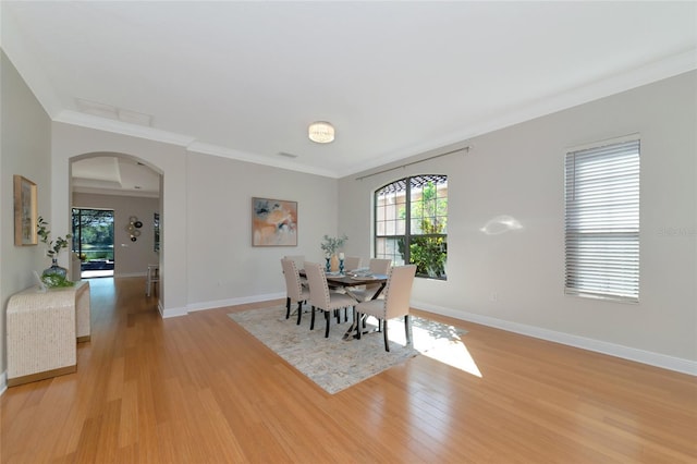 dining room featuring light hardwood / wood-style floors and crown molding