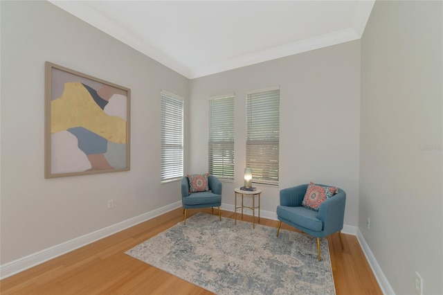 sitting room with hardwood / wood-style flooring and ornamental molding