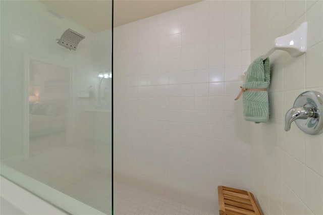 bathroom with tiled shower and tile walls