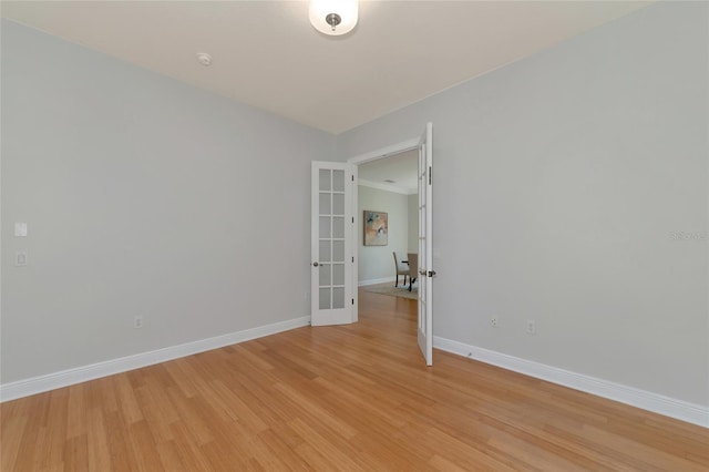 spare room with french doors and light hardwood / wood-style floors