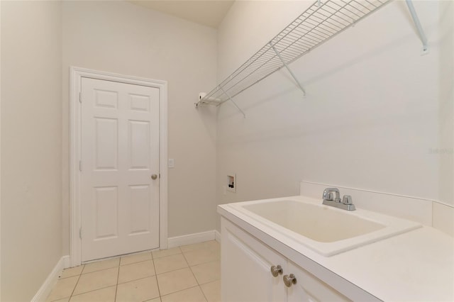 laundry room featuring cabinets, hookup for a washing machine, light tile patterned floors, and sink