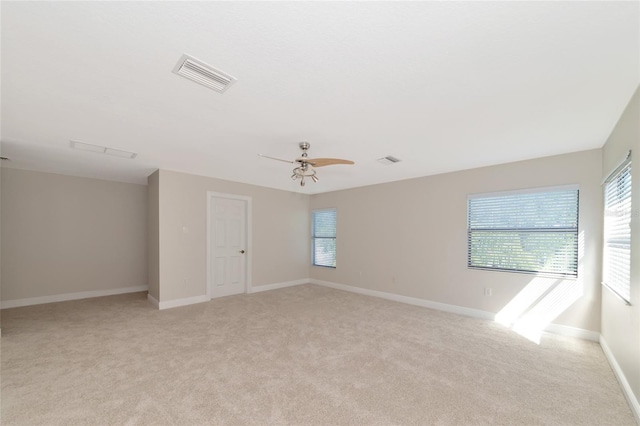 carpeted spare room featuring ceiling fan