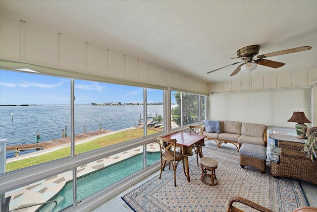 sunroom / solarium with a water view and ceiling fan