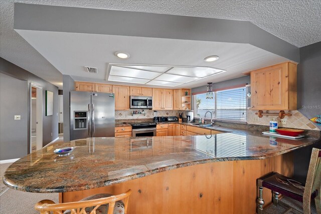 kitchen featuring stainless steel appliances, a kitchen breakfast bar, backsplash, and kitchen peninsula