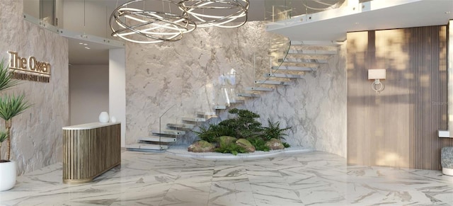 stairway with tile flooring, a towering ceiling, an inviting chandelier, and tile walls