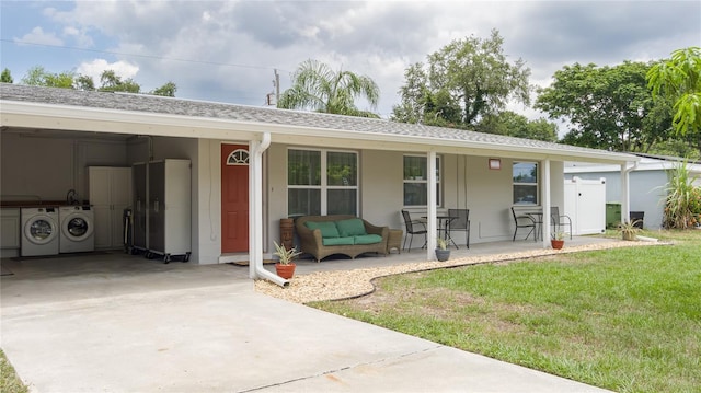 rear view of house with washer and clothes dryer, a porch, and a lawn