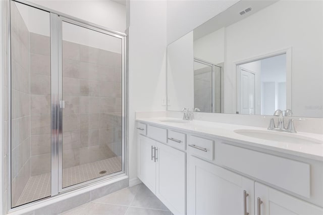 bathroom featuring a shower with shower door, vanity, and tile patterned flooring