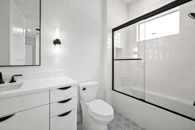 full bathroom featuring combined bath / shower with glass door, vanity, and toilet