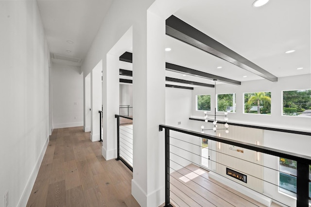 hallway featuring beam ceiling and light wood-type flooring