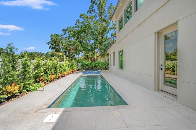 view of pool with a patio area and an in ground hot tub