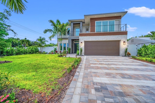 contemporary home with a front yard, a balcony, and a garage