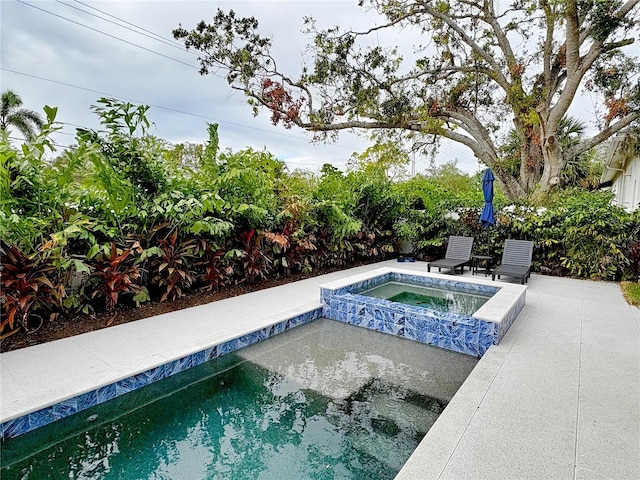 view of swimming pool with an in ground hot tub