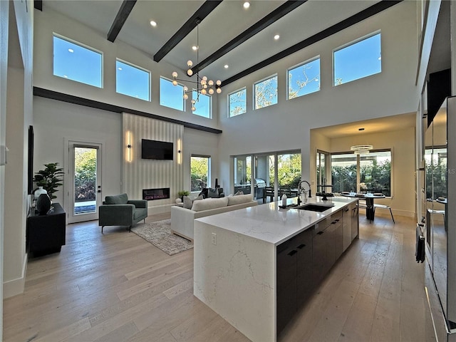 kitchen featuring beamed ceiling, a high ceiling, plenty of natural light, and a spacious island