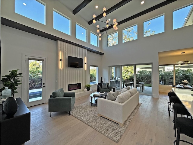 living room with a notable chandelier, a healthy amount of sunlight, and a high ceiling