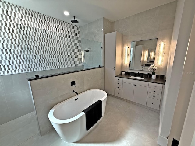 bathroom featuring vanity, tile walls, and independent shower and bath