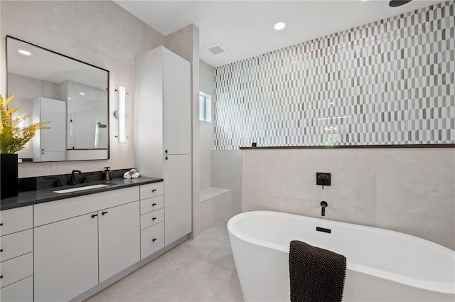 bathroom featuring shower with separate bathtub, vanity, and tile walls