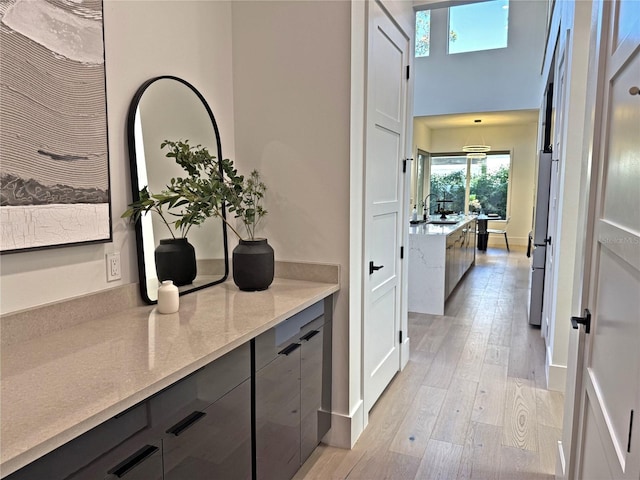 hallway with light hardwood / wood-style floors and sink