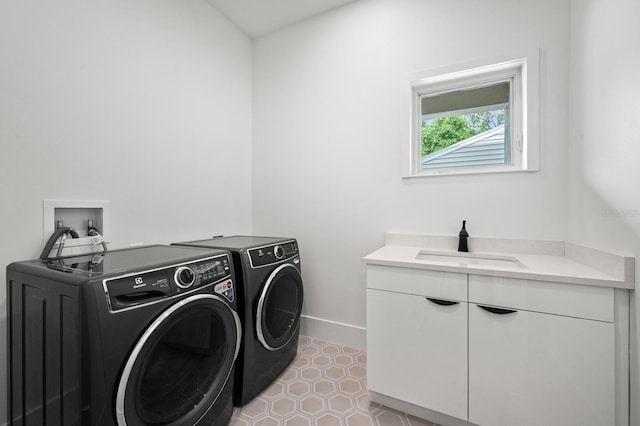 laundry room with cabinets, sink, and washer and dryer