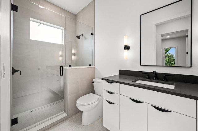 bathroom featuring tile patterned flooring, vanity, a healthy amount of sunlight, and toilet