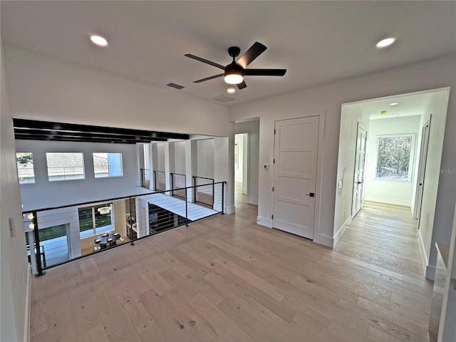 unfurnished living room with light hardwood / wood-style flooring and ceiling fan