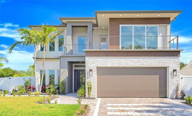 1805 Goldenrod St, Sarasota, FL 34239 - view of front of property with an attached garage, fence, a balcony, and stone siding