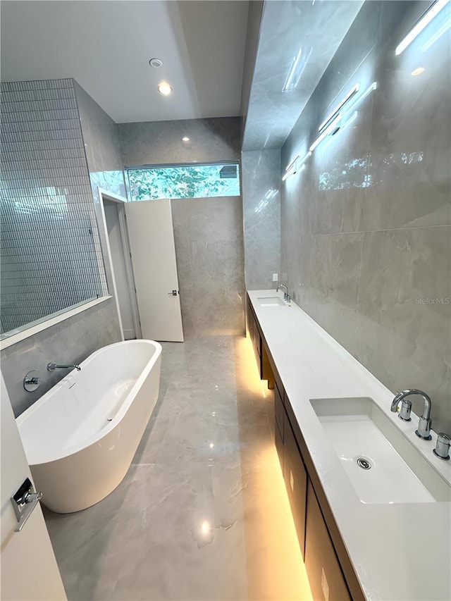 bathroom featuring vanity, tile walls, and a washtub