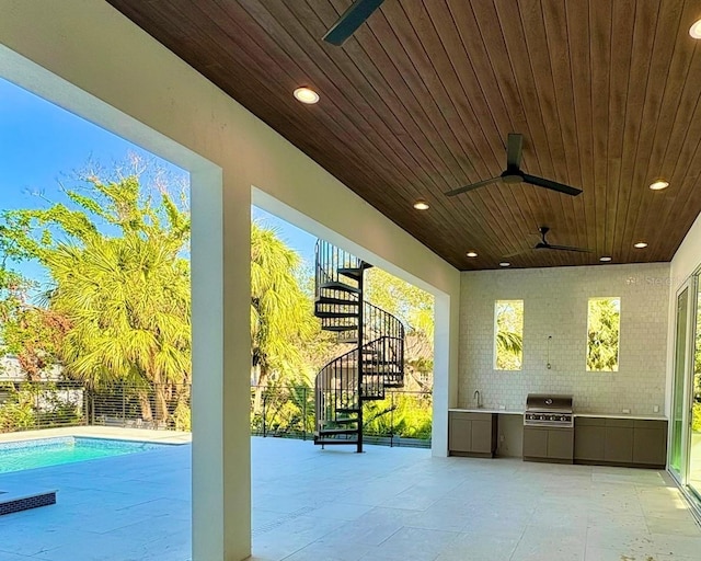 view of patio featuring ceiling fan, exterior kitchen, and grilling area