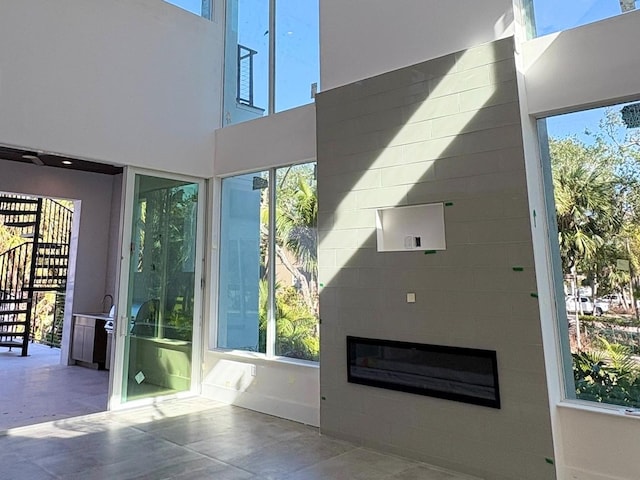 doorway featuring a high ceiling, a wealth of natural light, and concrete floors