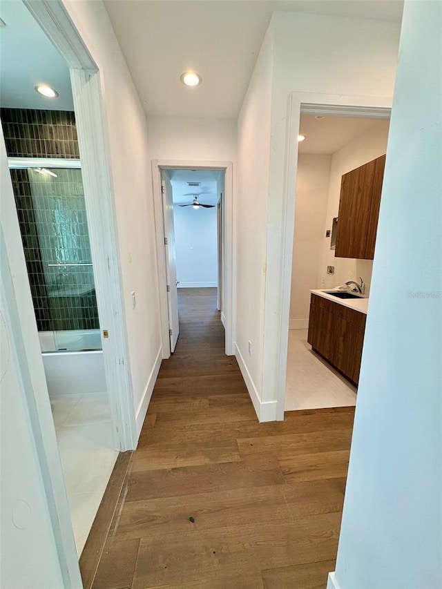 hallway with sink and light hardwood / wood-style flooring