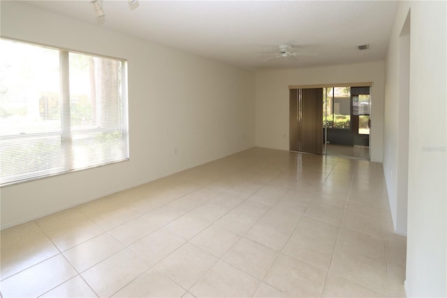 unfurnished room with light tile patterned floors, plenty of natural light, and ceiling fan