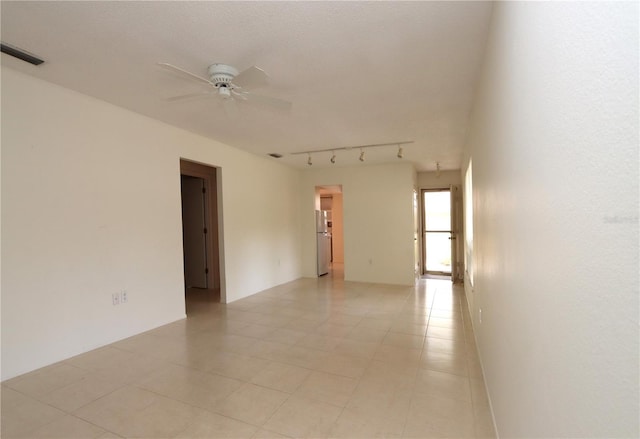 spare room featuring rail lighting and ceiling fan