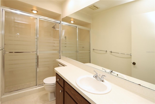 bathroom featuring tile patterned flooring, vanity, toilet, and an enclosed shower