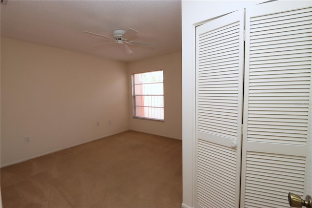 unfurnished bedroom featuring light carpet, a closet, and ceiling fan