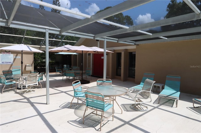 view of patio with glass enclosure