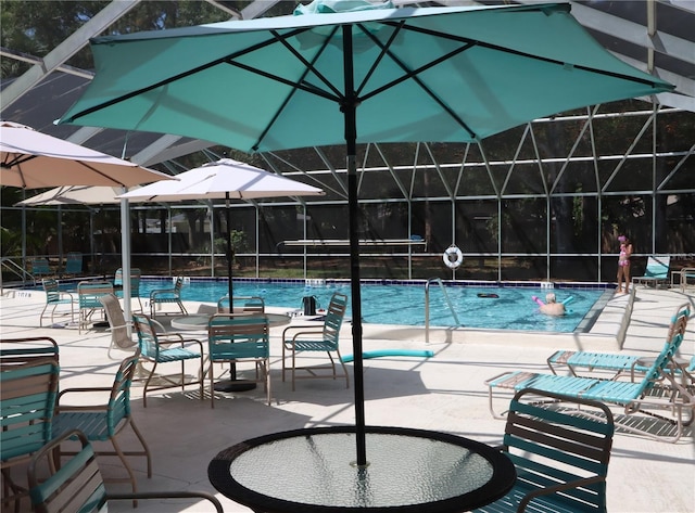 view of swimming pool featuring a lanai and a patio