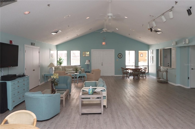 living room featuring wood-type flooring, rail lighting, ceiling fan, and lofted ceiling