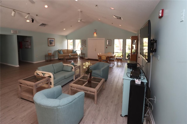 living room featuring ceiling fan, light hardwood / wood-style flooring, and lofted ceiling