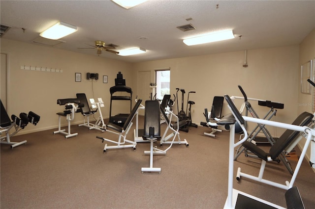 gym with ceiling fan and a textured ceiling