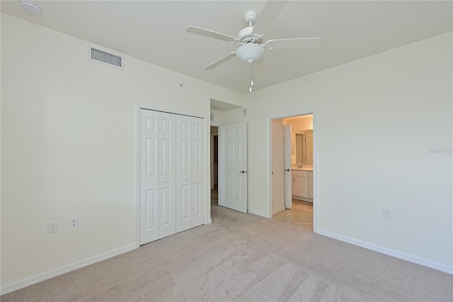 1020 Tidewater Shores Loop Unit 108, Bradenton, FL 34208 - unfurnished bedroom featuring light carpet, a closet, and ceiling fan