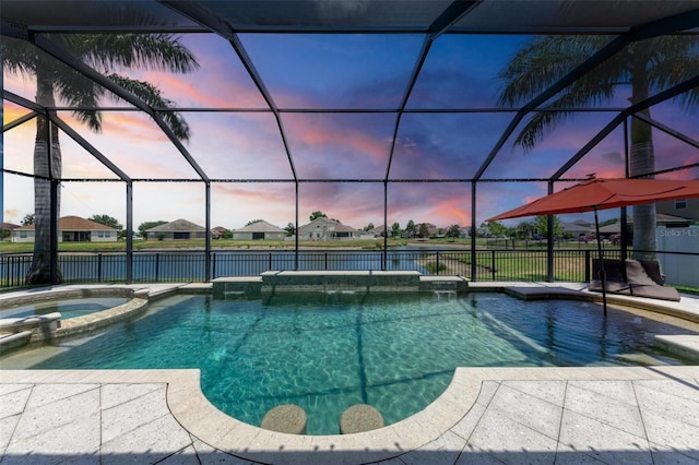 pool at dusk with pool water feature, a lanai, and an in ground hot tub