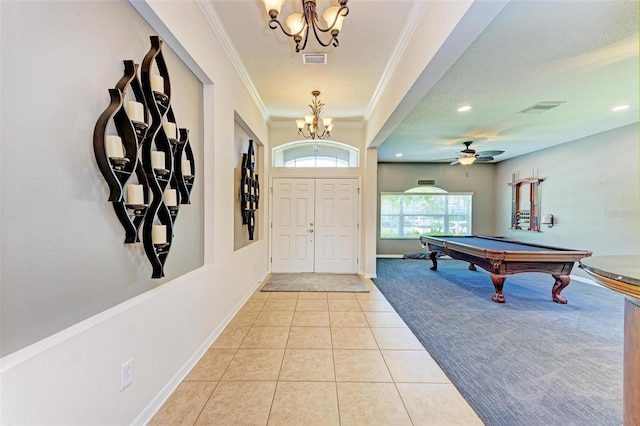 tiled entrance foyer featuring a textured ceiling, ceiling fan with notable chandelier, crown molding, and billiards