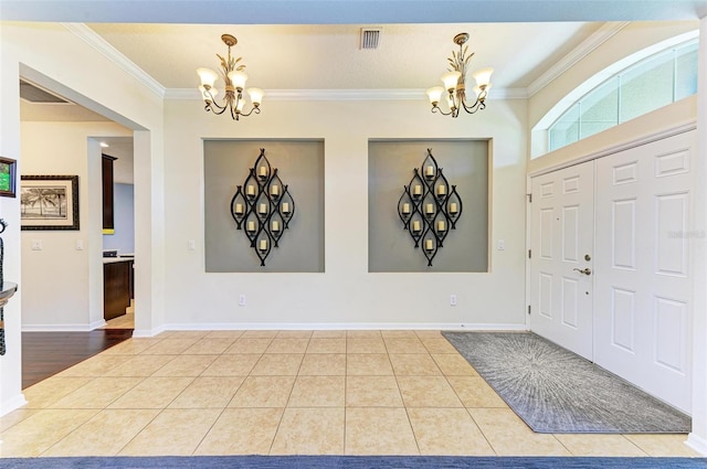 tiled foyer featuring crown molding and a notable chandelier