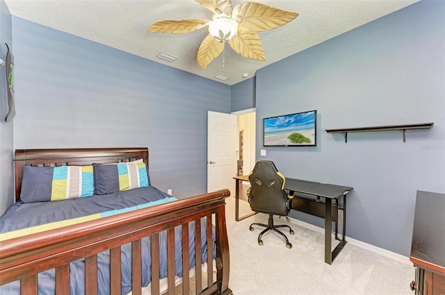 carpeted bedroom featuring ceiling fan and a textured ceiling